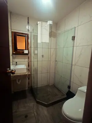 a bathroom with a shower with a sink and a toilet at Refugio Andino Cusco in Cusco