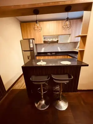 a kitchen with a black island with two bar stools at Estancia Ideal in Lima