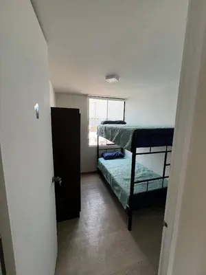 a small room with two bunk beds and a window at Prescott Apartment San Isidrio in Lima