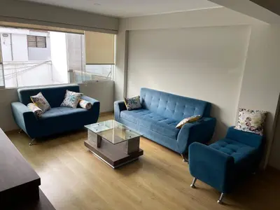 a living room with two blue couches and a coffee table at Room with 2 beds - Shared Apartment in Lima