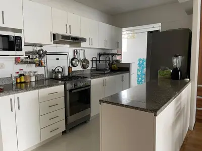 a kitchen with white cabinets and a black refrigerator at Room with 2 beds - Shared Apartment in Lima