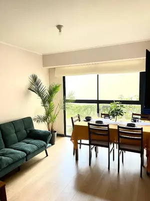 a living room with a table and a green couch at Modern Apartment for 9 San Isidro in Lima