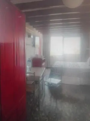 a room with a bed and a table and a red door at Miraflores Effyciency 5to piso in Lima