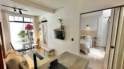 a living room with a couch and a table and a bedroom at Mini in Punta Hermosa