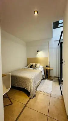 a bedroom with a bed and a chair in it at Mini in Punta Hermosa