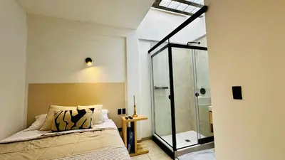 a bedroom with a bed and a glass shower at Mini in Punta Hermosa