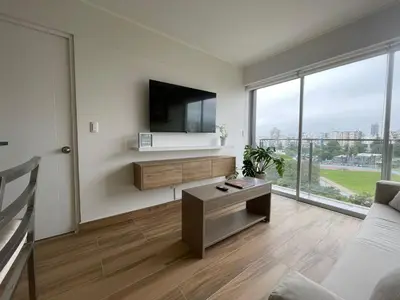 a living room with a flat screen tv on a wall at BOEM Apartments by Vibrant in Lima