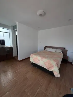 a bedroom with a bed and a wooden floor at Chincha CasaLed y jacuzzis sol todo el año in Tambo de Mora