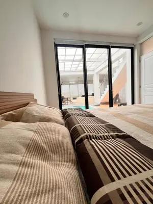 a bedroom with two beds and a large window at Chincha CasaLed y jacuzzis sol todo el año in Tambo de Mora