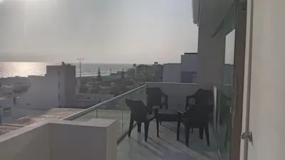 a balcony with chairs and a table on a building at Hermoso Departamento Con Vista Al Mar in Punta Hermosa