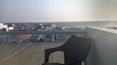 a black chair sitting on a balcony overlooking the ocean at Hermoso Departamento Con Vista Al Mar in Punta Hermosa