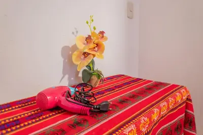 a vase with a flower on top of a table at Room A Charming Matrimonial Room in Historic San Blas in Cusco