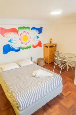 a bedroom with a bed with a painting on the wall at Room B Stylish Matrimonial Room for a Comfortable Stay in Cusco