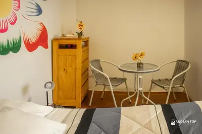a bedroom with a table and chairs and a bed at Room B Stylish Matrimonial Room for a Comfortable Stay in Cusco