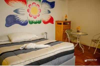 a bedroom with a bed with a flower mural on the wall at Room B Stylish Matrimonial Room for a Comfortable Stay in Cusco