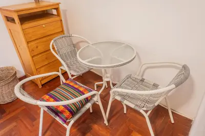three chairs and a glass table and two chairs at Room B Stylish Matrimonial Room for a Comfortable Stay in Cusco