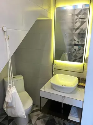 a bathroom with a sink and a toilet and a mirror at Olivar House Hotel in Lima
