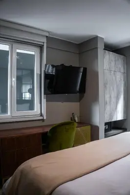 a hotel room with a bed and a tv on a wall at Olivar House Hotel in Lima