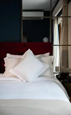 a white bed with a red headboard and white pillows at Olivar House Hotel in Lima
