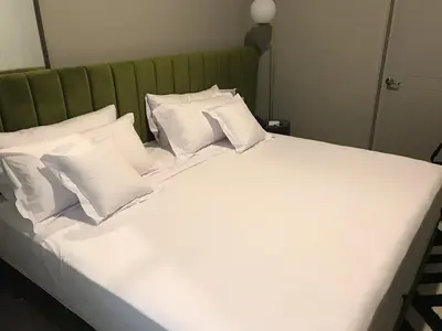 a large white bed with white pillows on it at Olivar House Hotel in Lima