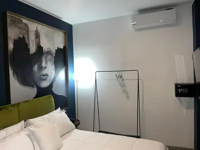 a bedroom with a bed with a large painting on the wall at Olivar House Hotel in Lima