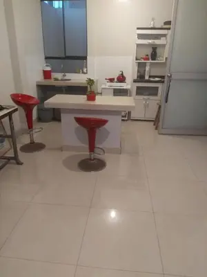 a kitchen with red stools and a white counter top at Agua dulce in Lima