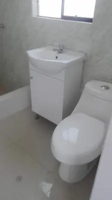 a white bathroom with a toilet and a sink at Agua dulce in Lima