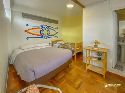 a bedroom with a bed with a painting on the wall at Room E Warm and Practical Room for Families or Friends in Cusco