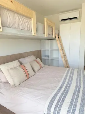 a bedroom with a bed with two bunk beds at Paracas Navigare 2 BD Vista Reserva y Mar Último piso Terraza Kamado BBQ in Santo Domingo