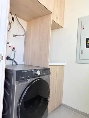 a washer and dryer in a small kitchen at Paracas Navigare 2 BD Vista Reserva y Mar Último piso Terraza Kamado BBQ in Santo Domingo