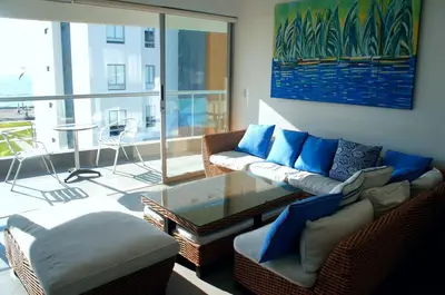 a living room with a couch and a table at Paracas Exclusivo Departamento familiar in Pisco