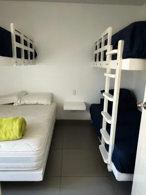 a dorm room with two bunk beds and a ladder at Paracas Exclusivo Departamento familiar in Pisco