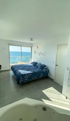 a bedroom with a bed and a bath tub at Paracas Exclusivo Departamento familiar in Pisco