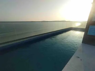 a swimming pool with the ocean in the background at COSTANERA Uno in Lima