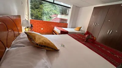 a bedroom with two beds and a large window at All sur departamento in Machu Picchu