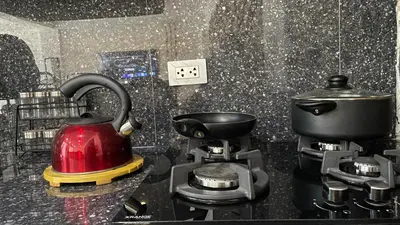 a red tea kettle on a stove in a kitchen at Casa Departamento en el Valle de Urubamba in Urubamba