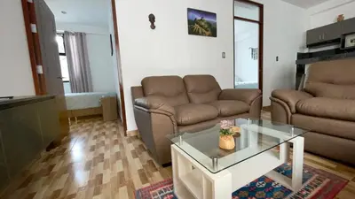 a living room with a couch and a coffee table at Casa Departamento en el Valle de Urubamba in Urubamba