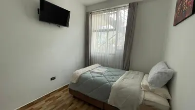 a small bedroom with a bed and a window at Casa Departamento en el Valle de Urubamba in Urubamba