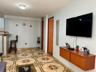 a living room with a flat screen tv on a wall at Cozy & Centric Apartment in great location! in Cusco