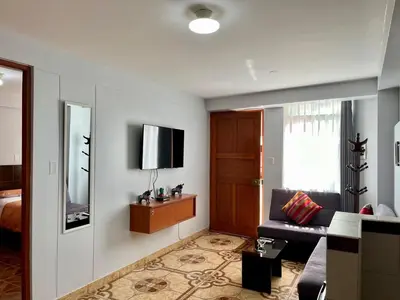 a living room with a couch and a television at Cozy & Centric Apartment in great location! in Cusco