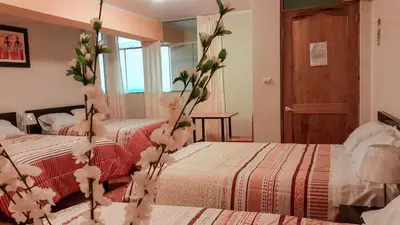 two beds in a room with flowers on the beds at Hotel Bartol in Huancayo