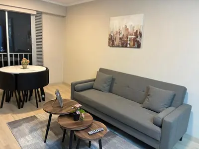 a living room with a couch and a table at Modern apartment overlooking Parque de las Aguas in Lima