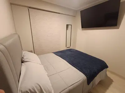 a bedroom with a bed and a flat screen tv at Comfortable apartment in Parque la Reserva in Lima