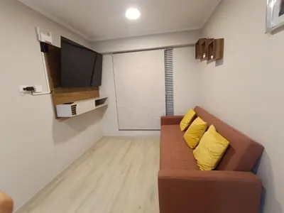 a living room with a brown couch with two yellow pillows at Comfortable apartment in Parque la Reserva in Lima