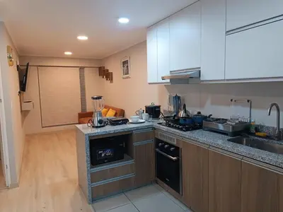 a kitchen with white cabinets and a counter top at Comfortable apartment in Parque la Reserva in Lima
