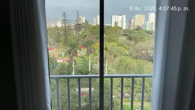 a view of a city from a window at Cozy apartment overlooking Parque de las Aguas in Lima