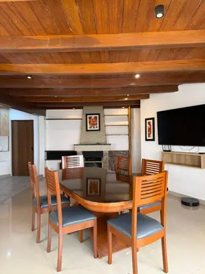 a dining room with a table and chairs and a television at Serendipia City Comfort Suite 901 in Lima
