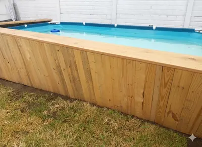 a wooden bathtub with a pool in the grass at Casa de campo El paraiso cerca a Lima in Nuevo Imperial