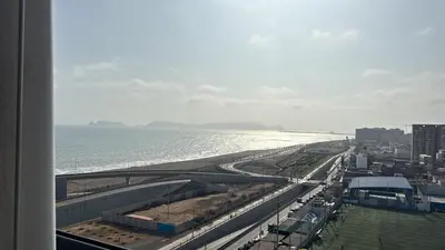 a view of a beach and the ocean from a building at Departamento completo vista al mar,piscina,gimnasio,WIFI,Tvs in Lima