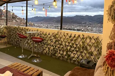 a bar with a view of a city from a window at Apartment with terrace and outdoor kitchen in Cusco